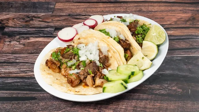 Street tacos with onion, cilantro, and lime at Tacos Nicole in Middletown, New York